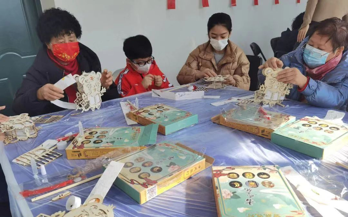 居民们兴致勃勃、相互分工，合力DIY制作虎年元宵节创意灯笼。东城区供图