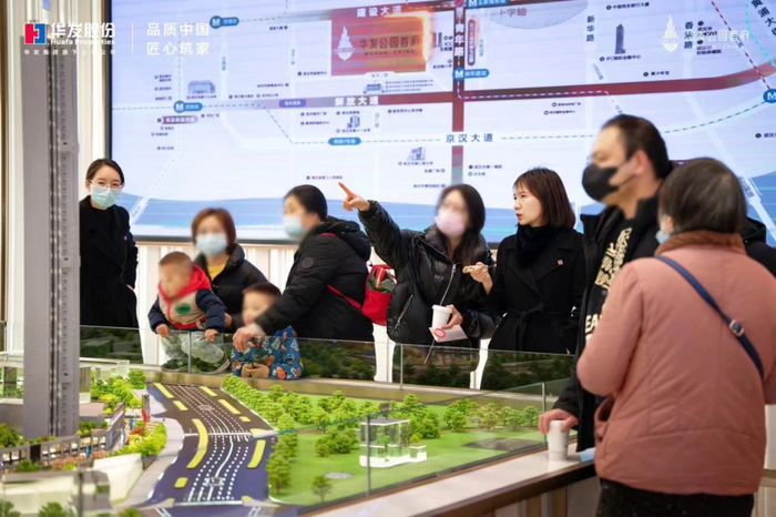 （在华发公园首府营销大厅，购房者在听置业顾问介绍）