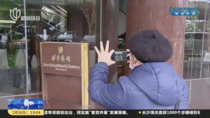 　曹明德拿着相机纪录改造前的华亭宾馆 上视新闻截图