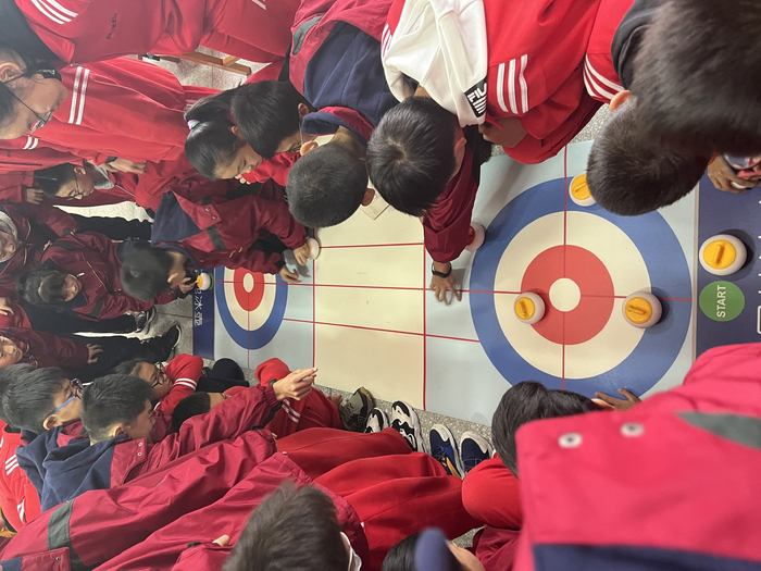 2018年，学生们在教室里铺上游戏冰壶毯，学习冰壶课程。 受访者供图