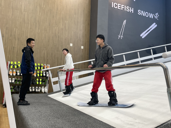 夏钊伟（左一）指导高三学生滑雪技术动作。 新京报记者杨柳 摄