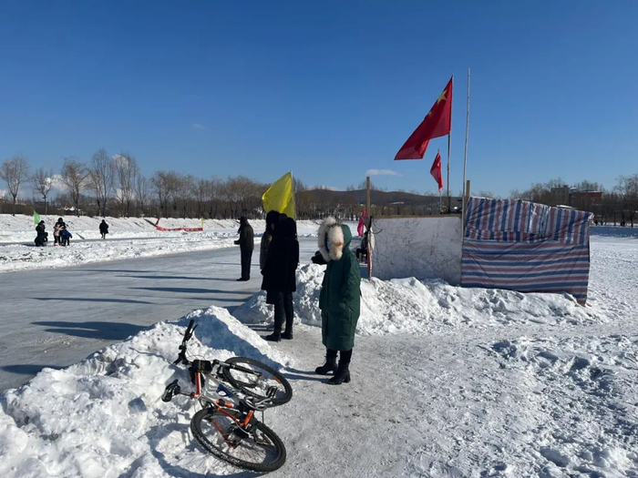 　　2022年2月13日，最低气温零下29摄氏度，几位家长在寒风中等候滑野冰的孩子。新京报记者 杜寒三 摄
