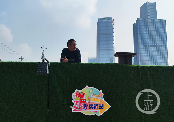 中央公园建筑工地，趴在围墙上晒太阳的工人。冉文 摄