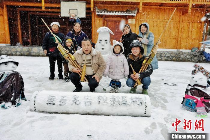 苗族民众拿着苗族传统乐器芦笙在雪前合影。　梁强 摄