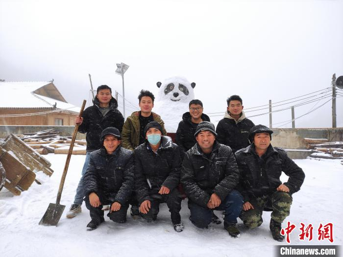 苗族民众在自己堆的大熊猫雪人前合影。　梁强 摄