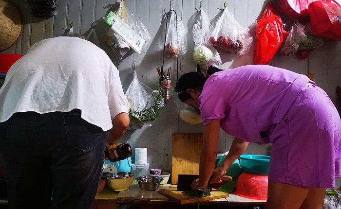 铁板房里，墙上挂满了蔬菜。图片来源：界面海南 