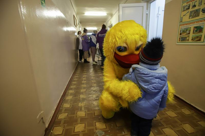 2022年2月20日，安置点的志愿者扮成孩子们喜欢的形象安抚难民儿童。