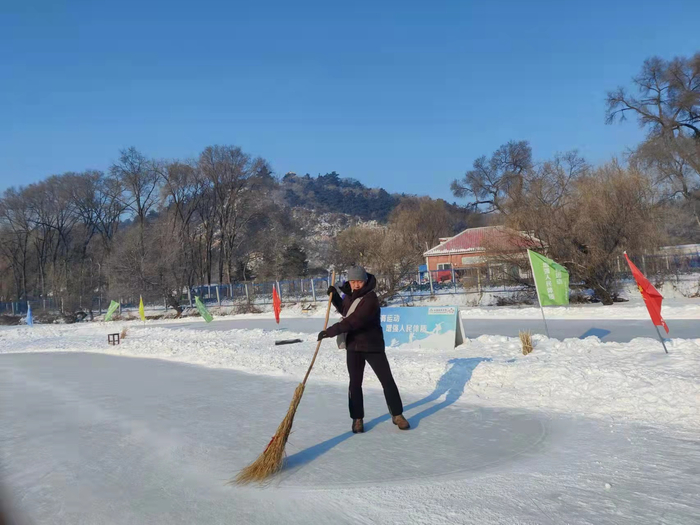 王峰清理冰场上的积雪。受访者供图