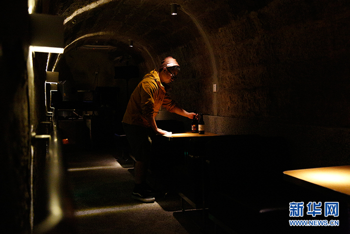 工作人员在利用防空洞改造的酒吧内整理桌面。（2021年11月11日摄）新华网　耿骏宇　摄