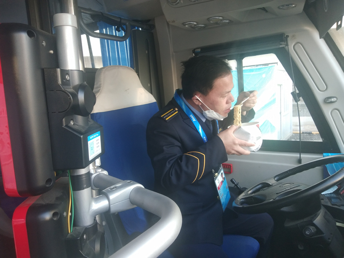 北京公交集团冬奥B2车队驾驶员姬朋新在驾驶舱内休息、吃泡面。受访者供图