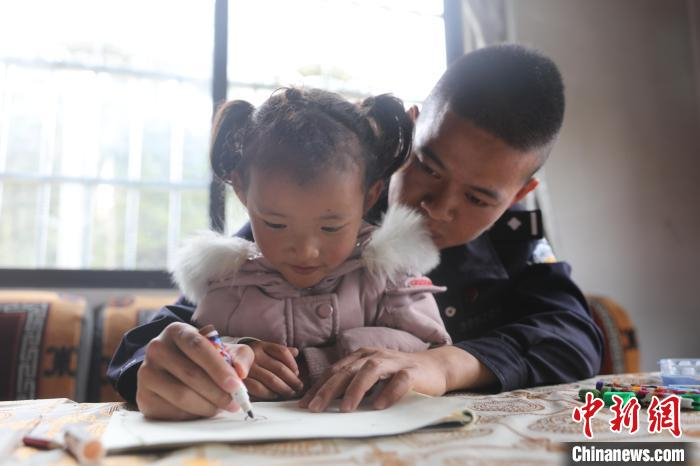 图为林芝南伊边境派出所民警沈朋在走访时教小旺姆写字。　马智慧 摄