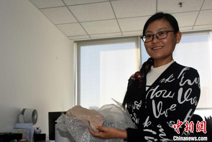 杨石霞接受采访时展示研究的石器遗存。　中新社记者 孙自法 摄