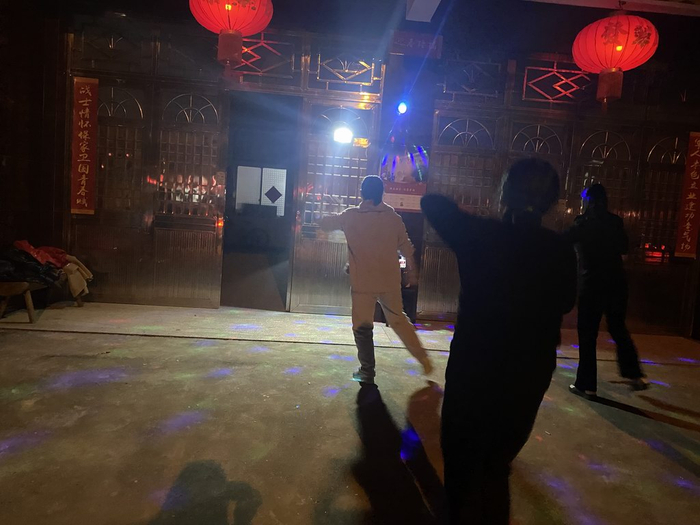 她兴兴头头地去公路对面跳广场舞，热门配乐之一是《冬天里的一把火》