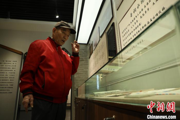 郭华老人正在讲解村使馆内陈列物品背后的故事。　向上 摄