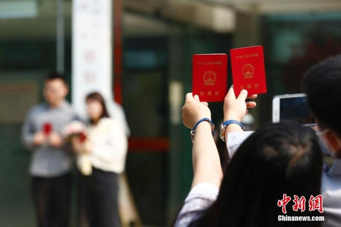 资料图：新人在婚姻登记处外拍照留念。 中新社记者 富田 摄