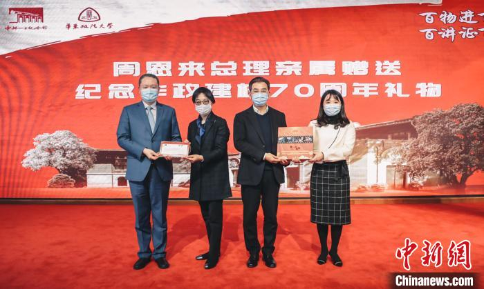 周婧祎、唐华向华东政法大学赠送首日封和相关纪念册。　华东政法供图