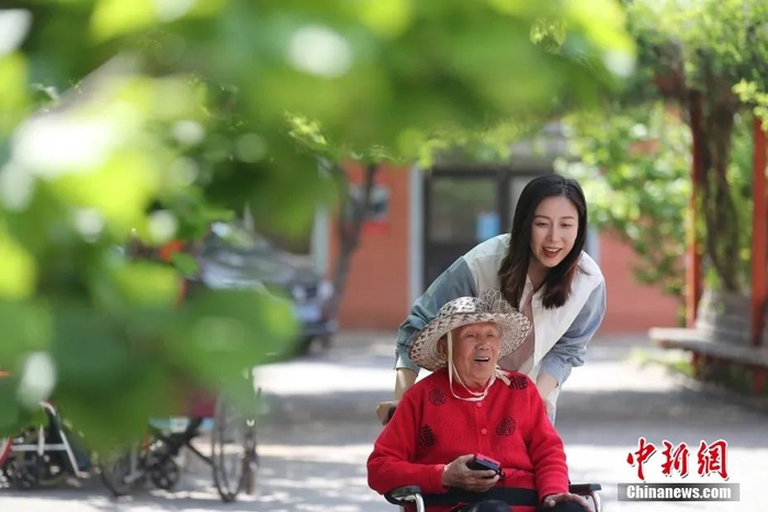 沈阳天柱山老年公寓院长陈思在公寓中陪老人晒太阳。中新社记者 于海洋 摄