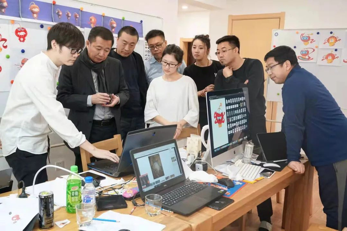 ▲“125工作组”在工作室讨论修改方案。受访者供图