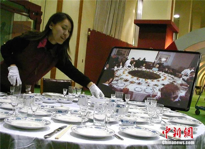 　2002年，北京为纪念尼克松访华30周年及回顾中美关系举行《走向和平与合作之旅展》。一桌用当年宴请尼克松时所用的餐具摆放的宴席令参观者驻足。中新社发 陈艺 摄