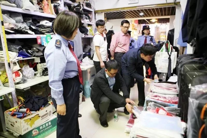市场监管人员查处侵权服装现场