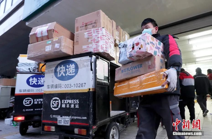 资料图：顺丰速运一快递小哥将快递装车。中新社记者 张宇 摄