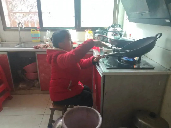 ▲3月7日中午，陈新平准备午饭，她需要把炒锅倾斜才能看到锅中的食物。新京报记者 李冰洁 摄