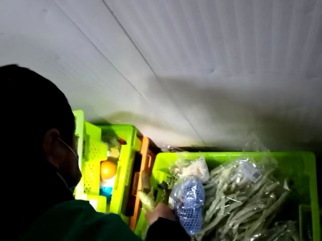 ▲2月9日晚，站长王明向记者“传授”如何处理“烂菜筐”中的物品。新京报记者 王瑞文 摄