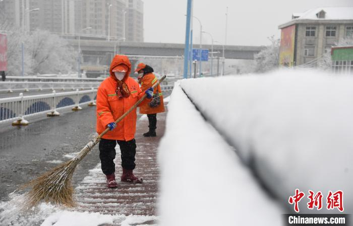 河北廊坊安次区环卫工人正在清扫积雪，保障疫情期间道路通行顺畅。　刘向 摄