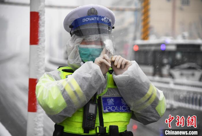 图为廊坊市广阳区一名执勤交警擦拭护目罩上的积雪。　刘向 摄