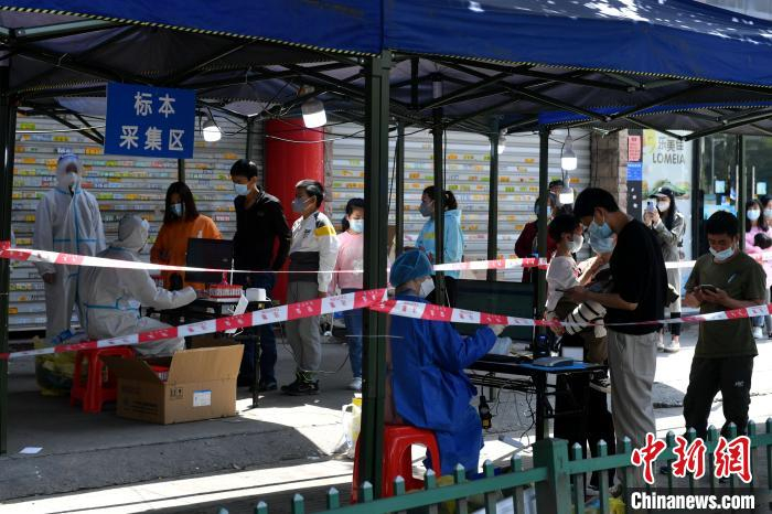 图为管控区内的居民排队等待核酸检测采样。　吕明 摄