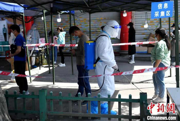 图为管控区内的居民排队等待核酸检测采样。　吕明 摄
