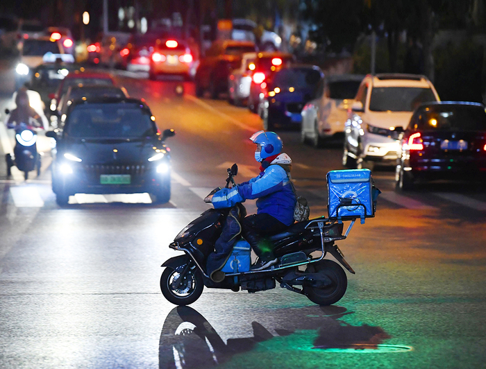 一外卖小哥冒着严寒奔波街头。