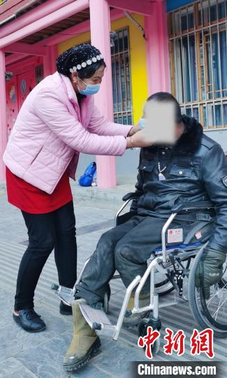 图为孔小红照顾残疾人。　韩丽 摄