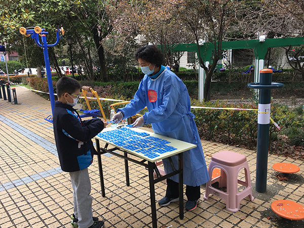 林慧莉给居民发放“已采”卡片