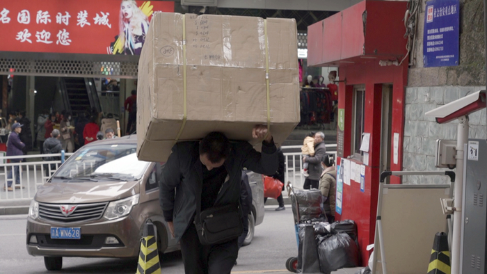 ▲2月28日，冉光辉扛着板车穿梭在大成商城里。新京报记者&nbsp;杨雪&nbsp;摄