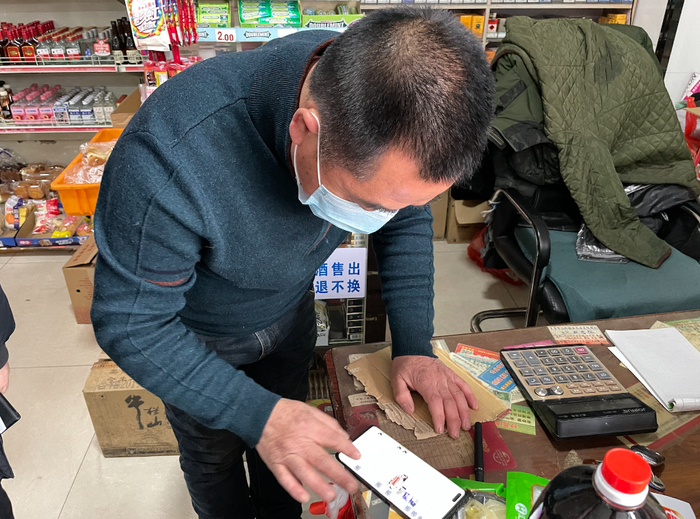 　　五常市沙河子镇东兴超市经营者施小平在线上接收订单。新华社记者 王鹤 摄