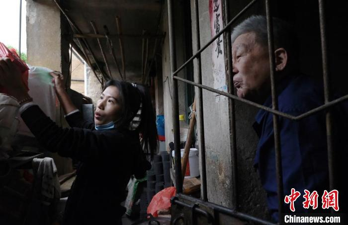 图为黄文婷帮助居民清理楼道杂物，普及消防安全知识。　吕靖中 摄