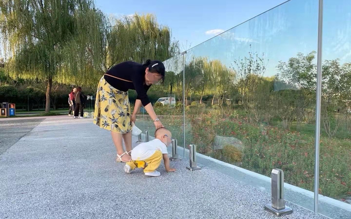 洵洵妈妈在户外陪伴孩子玩耍。受访者供图