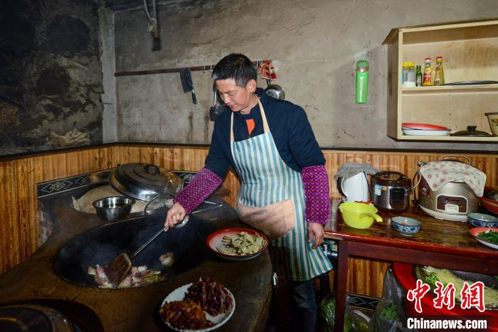酉阳县内口村村民冉华龙在自家的民宿内为游客准备特色农家菜。　何蓬磊 摄
