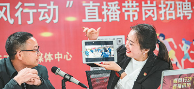 江西省吉安市新干县“春风行动”线上招聘直播带岗现场招聘会上，主播正在用平板电脑展示用工企业文化。李福孙摄