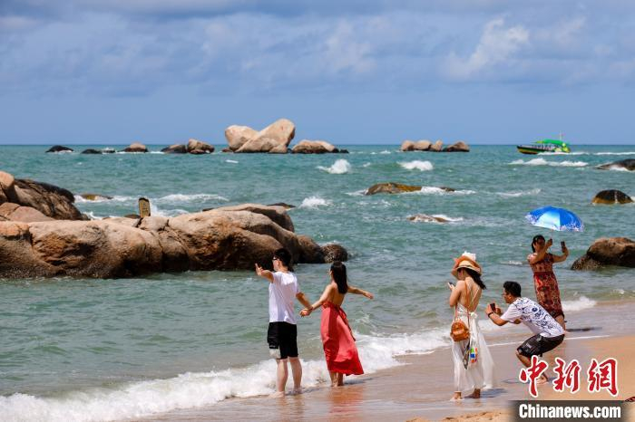 资料图：游客在天涯海角的海边沙滩“拥抱大海”。　范勇　摄