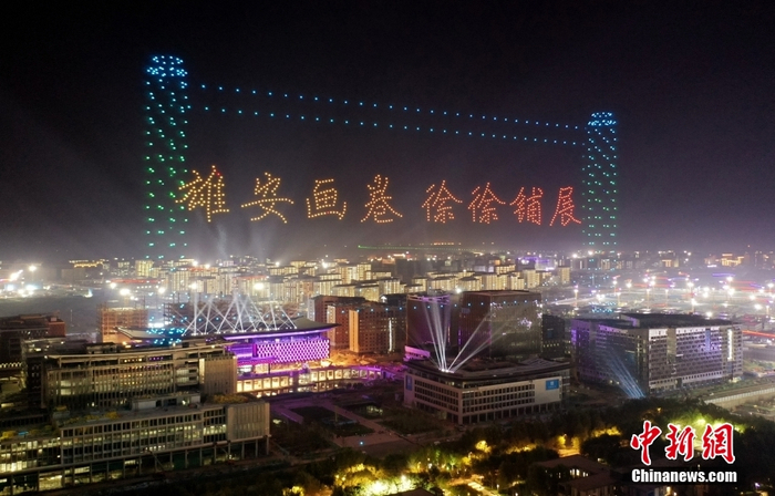 资料图：2021年7月1日凌晨，河北雄安新区上千台无人机上演灯光秀表演，排列出各种文字与图案，“点亮”雄安夜空。图为无人机排列出“雄安画卷 徐徐铺展”字样。（无人机照片） 中新社记者 韩冰 摄
