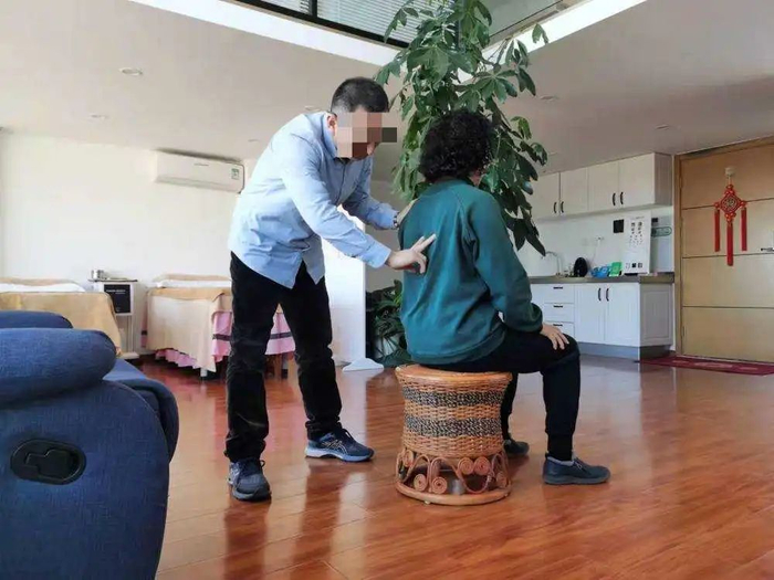 讲师在给学员点穴，宣称能驱寒治风湿。人民网 游天燚 摄