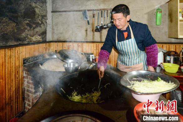 村民冉华龙开办民宿，为游客提供餐饮服务。　何蓬磊 摄