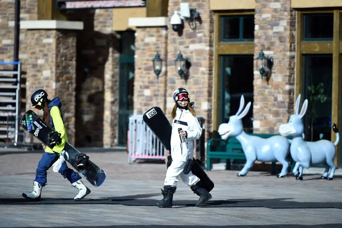 河北省张家口市崇礼区的太舞滑雪小镇，游客带着雪板走向雪场