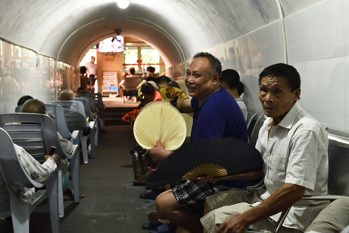 2018年7月20日，重庆渝中区，在防空洞内避暑的人们。 IC 资料图