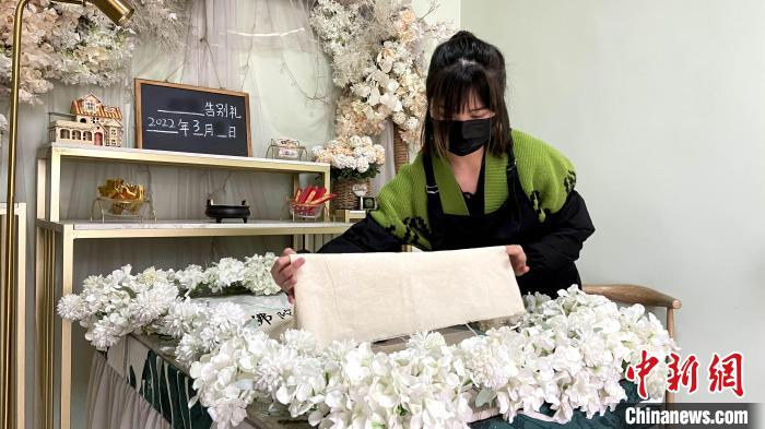 “90后”宠物殡葬师为宠物盖上白布。　孙婷婷 摄