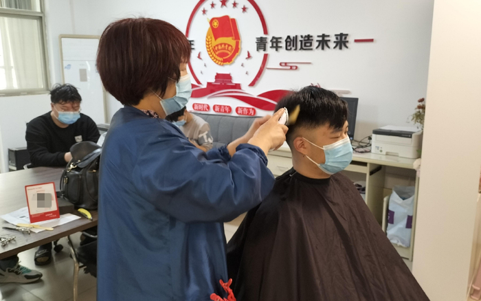 学生在“爱心理发小屋”内理发。受访者供图