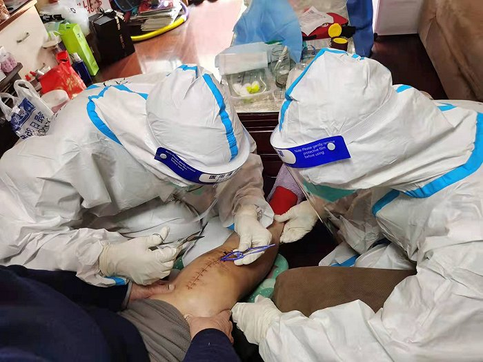 临时医疗队“全副武装”上门为居民拆线。 图片来源：受访者提供