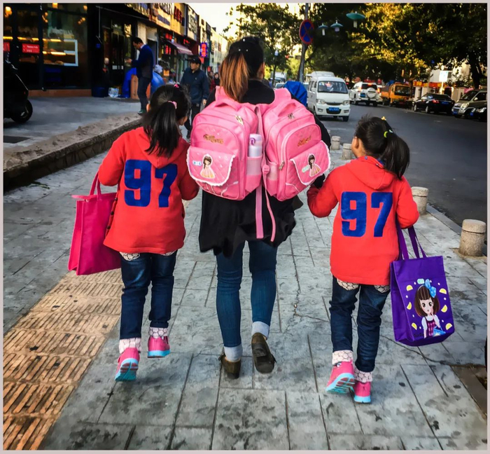 母亲送双胞胎孩子上学